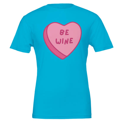 Turquoise T-shirt with a pink candy heart that says "Be Wine," perfect for wine lovers and Valentine's Day celebrations.