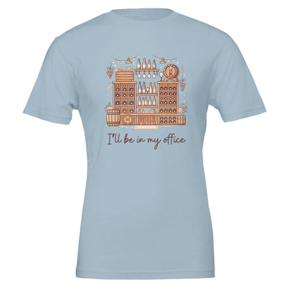 Light blue T-shirt featuring an intricate illustration of a wine cellar with barrels, shelves of bottles, hanging glasses, and the phrase "I'll Be in My Office" in a handwritten-style font.